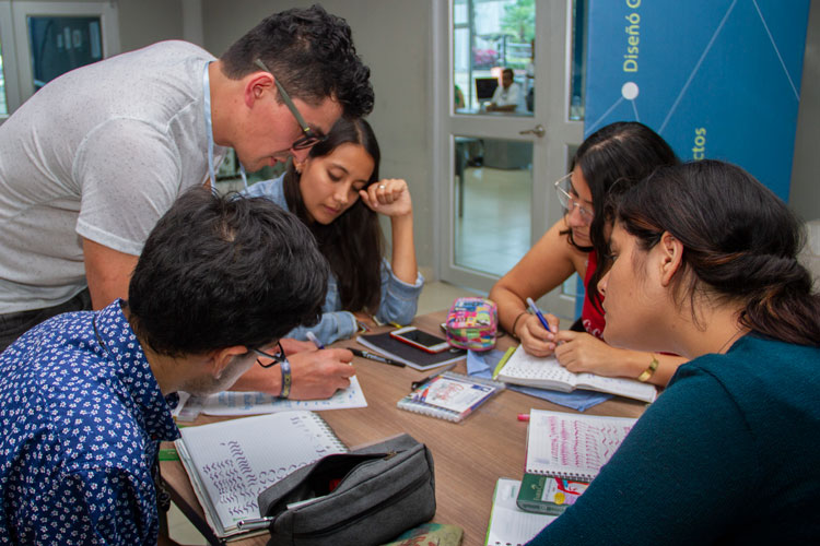 Instructuror junto alumnos taller tipografía