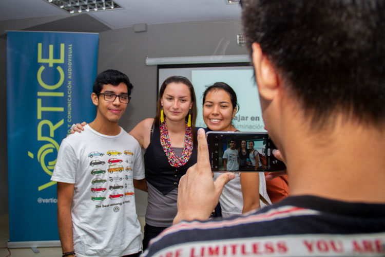 joven tomando una foto a tres personas