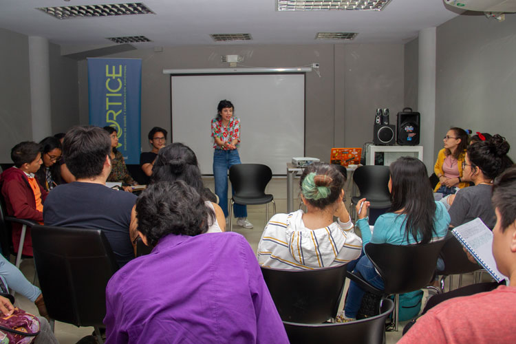 Grupo de personas recibiendo una charla de expositora