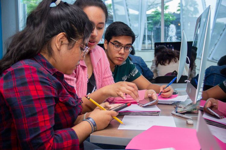 Jovenes trabajando frete a una computadora